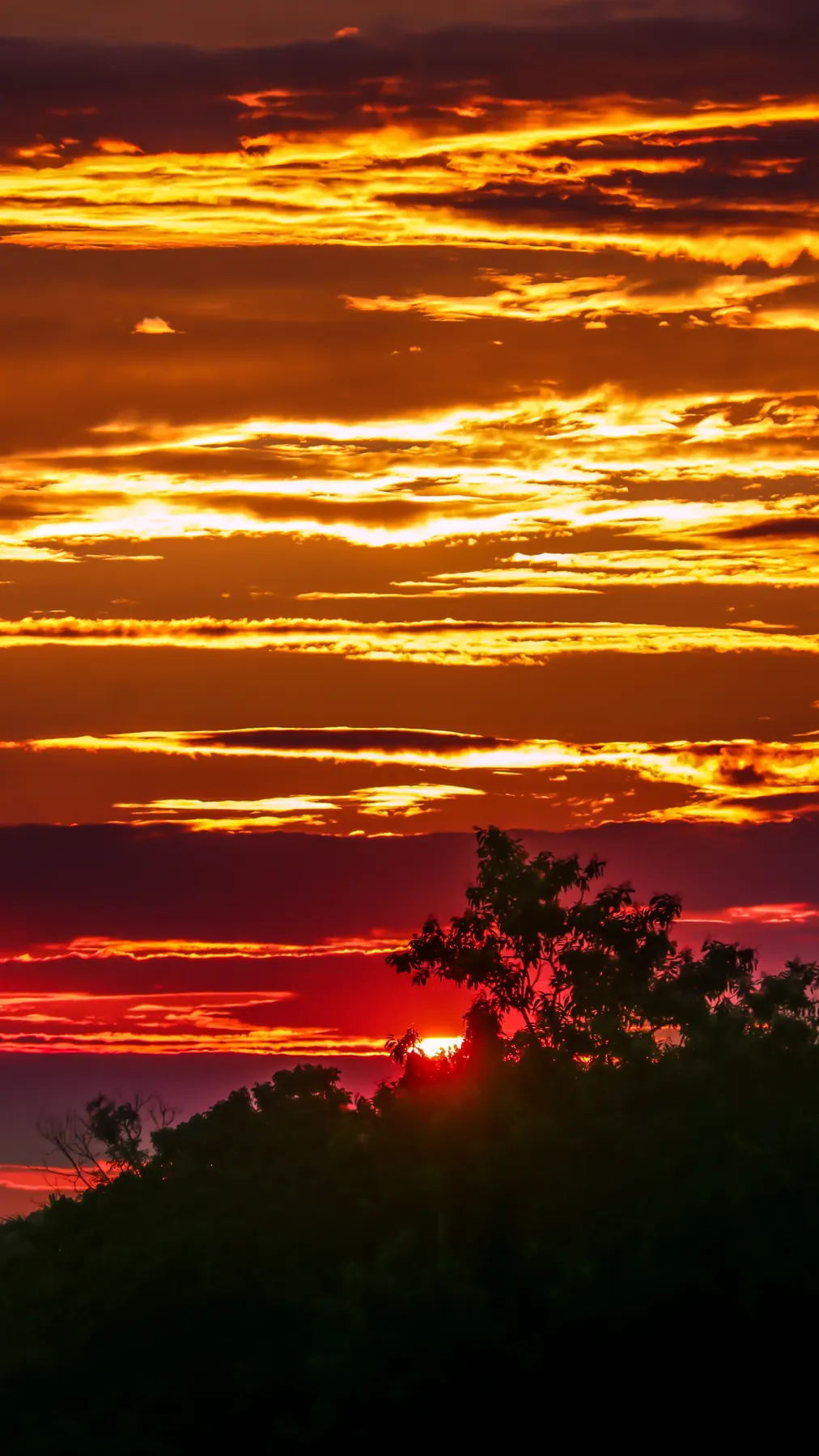 Layered orange storm clouds at sunset