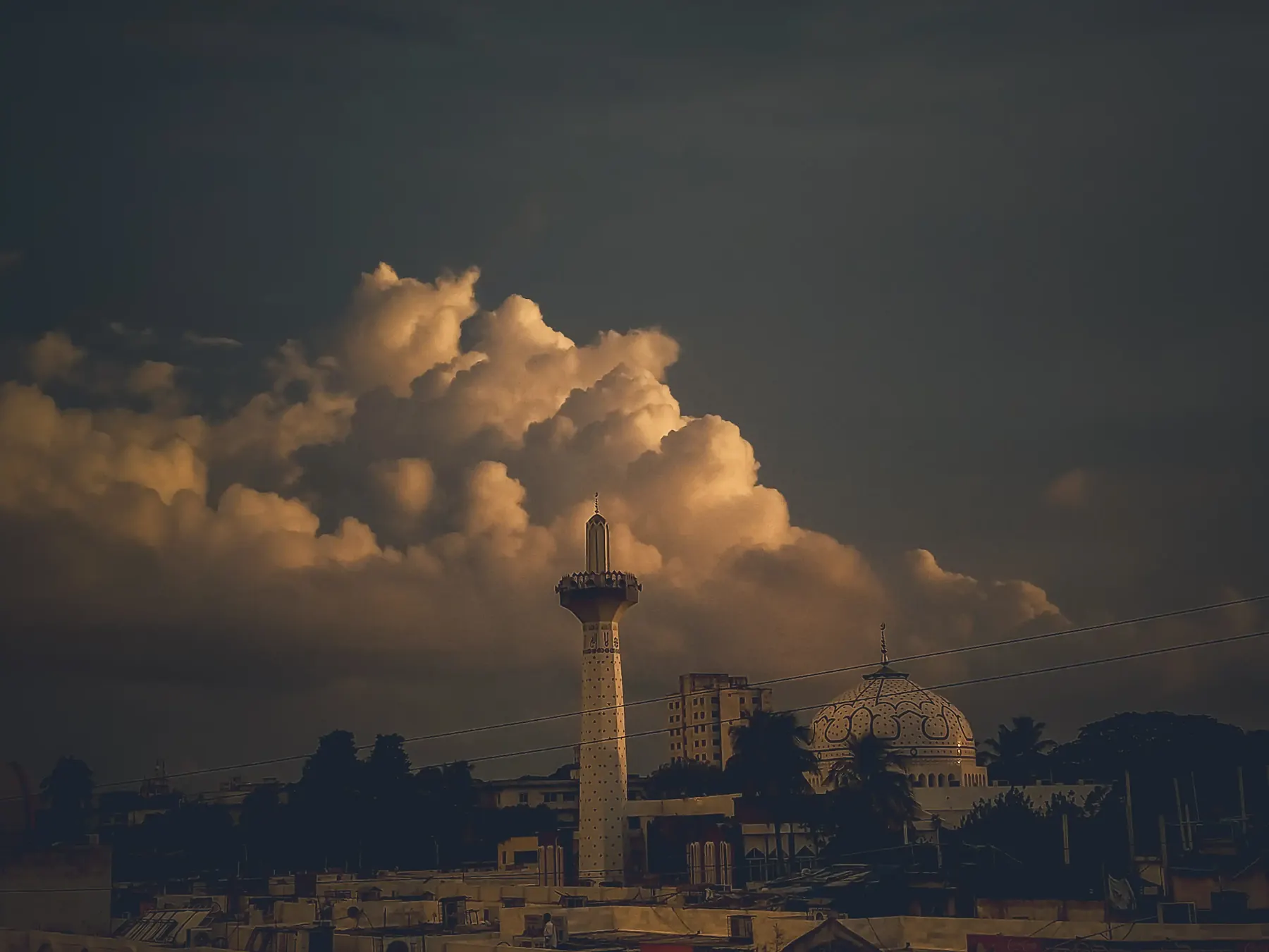 A hazy distant cityscape under a large cloud