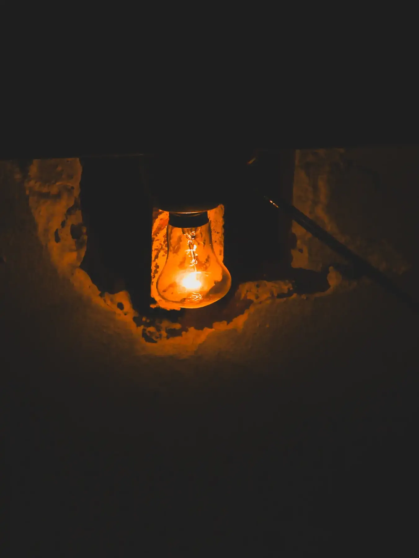 A lantern glowing warmly in a stone alcove