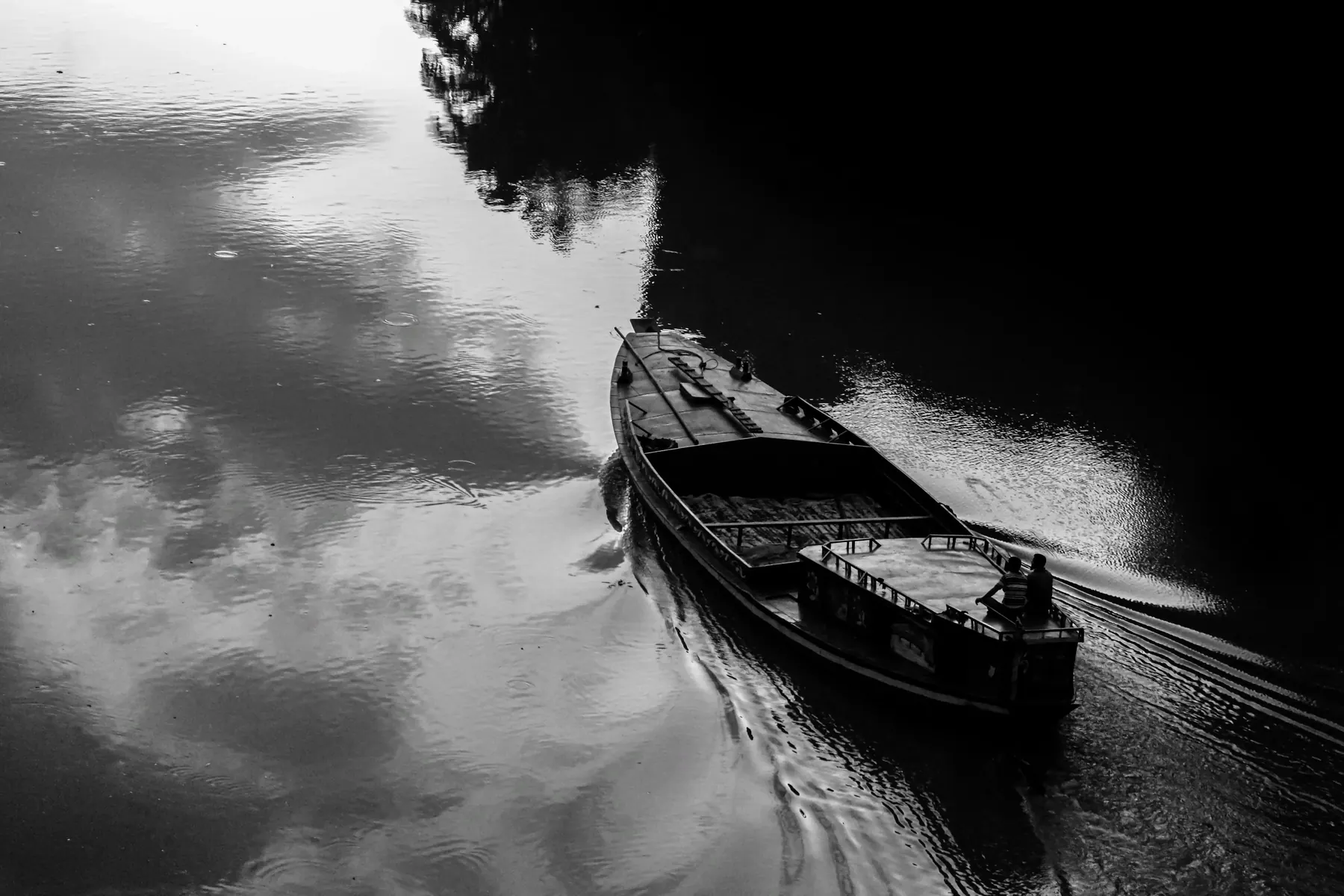 Black and white photo of a boat and oarsman on a river