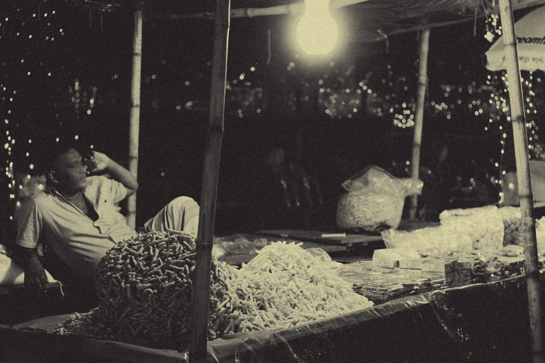 Black and white documentary shot of craftwork by lamplight