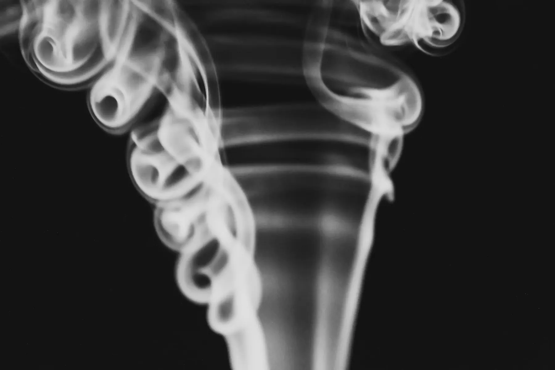 Abstract curling smoke against a black background
