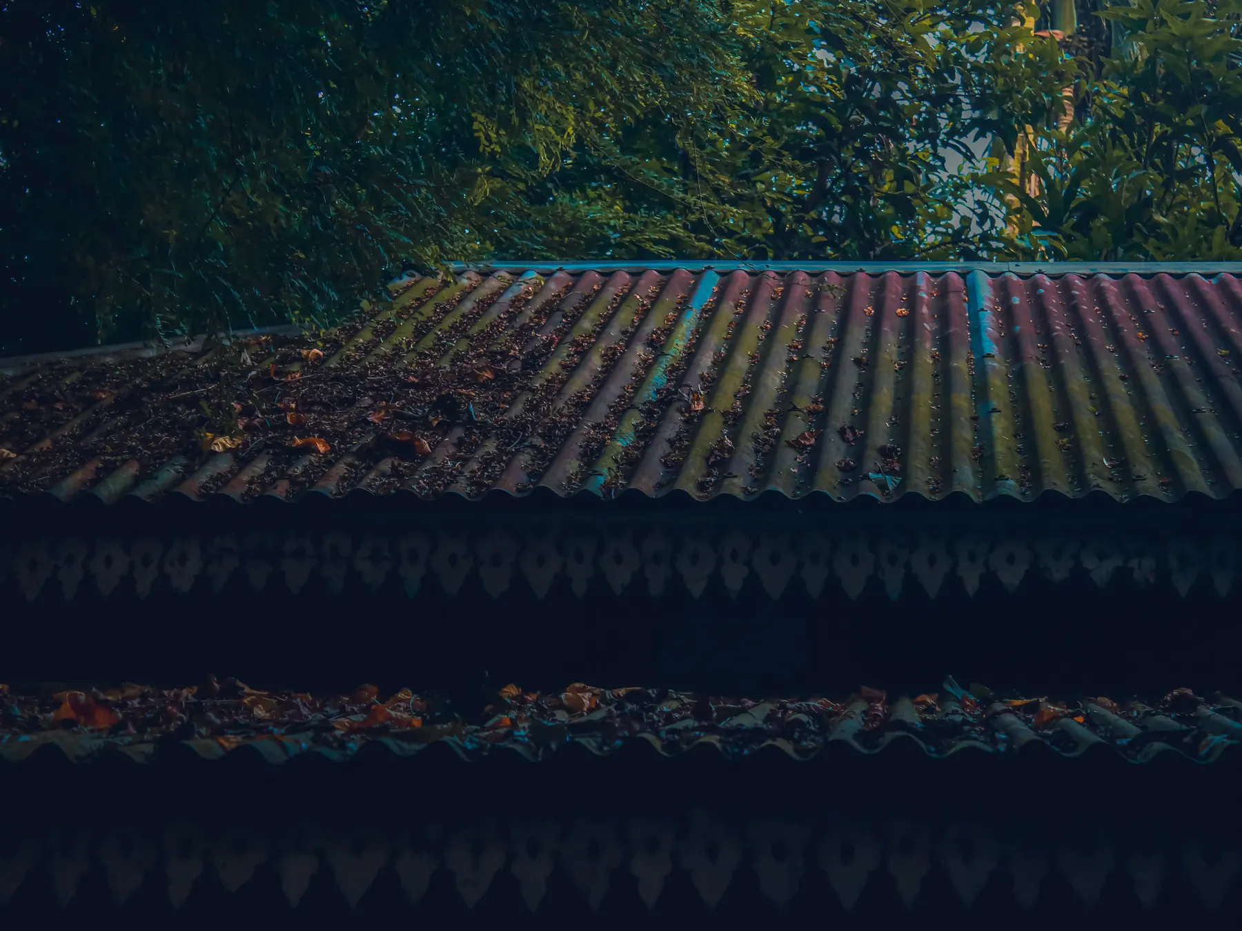 Textured clay roof tiles among green foliage